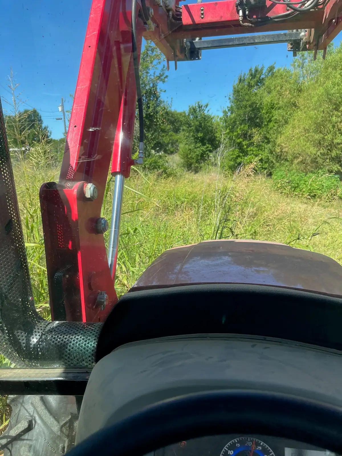 Tall summer grass and weeds before brush hog mowing, seen from the tractor near Granbury, TX