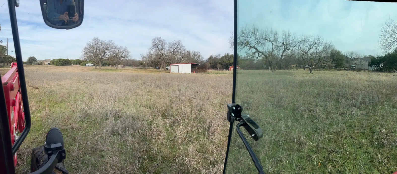 Brush hog mowing a pasture under mature oaks with a red tractor near Granbury, TX