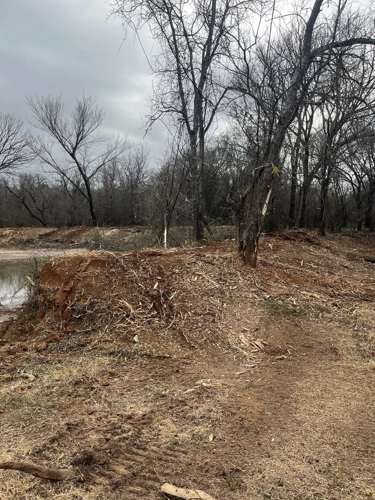 Stock pond banks cleared of brush and reshaped on a ranch near Granbury, TX